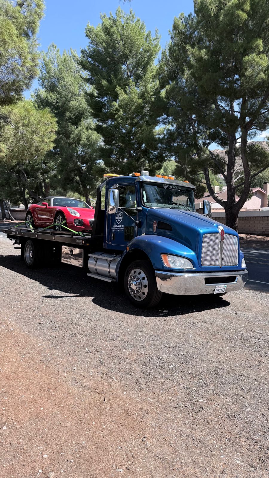 DBAB's blue tow truck transporting a classic vehicle